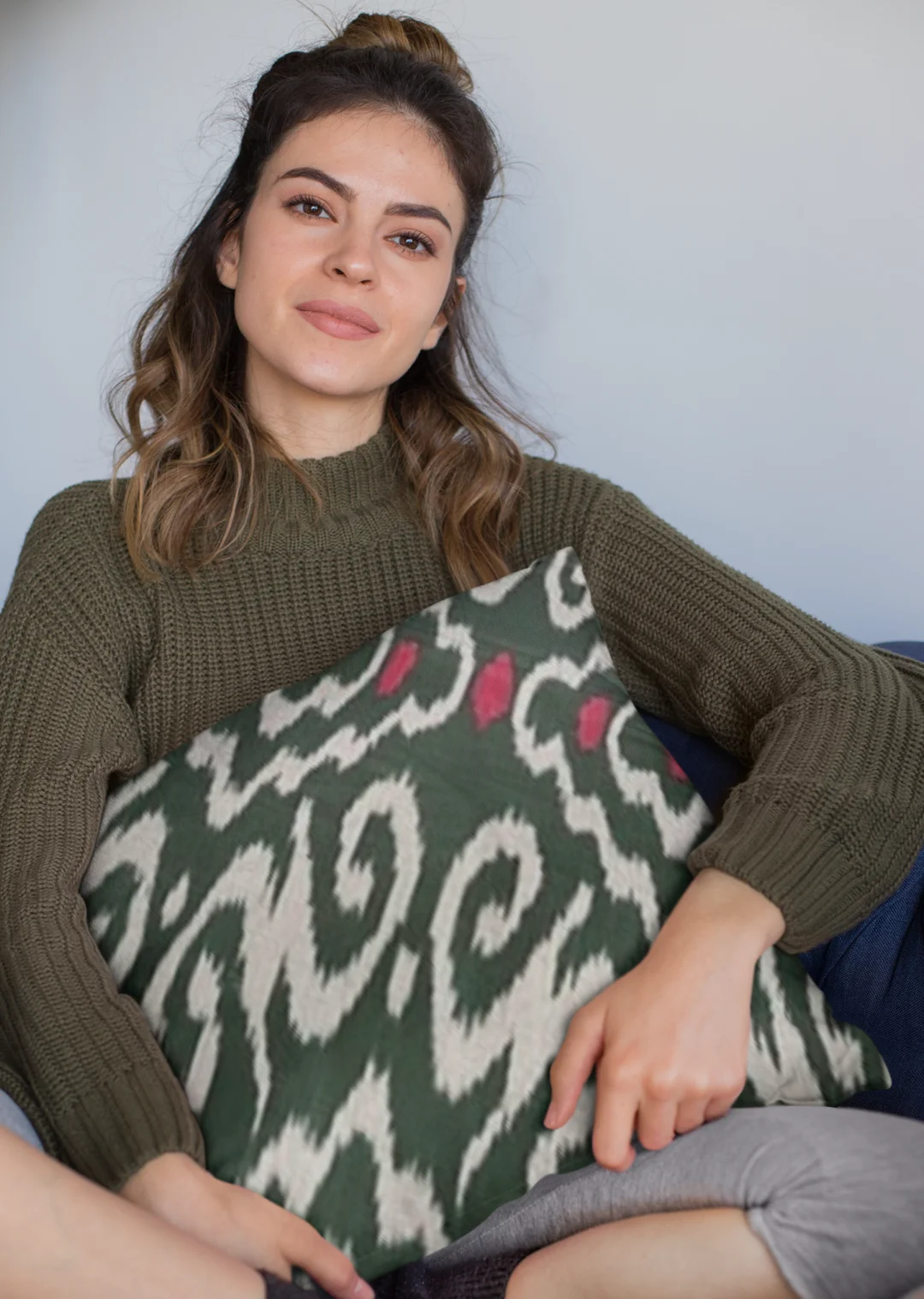 mockup of a woman holding a square pillow while sitting 23577 1